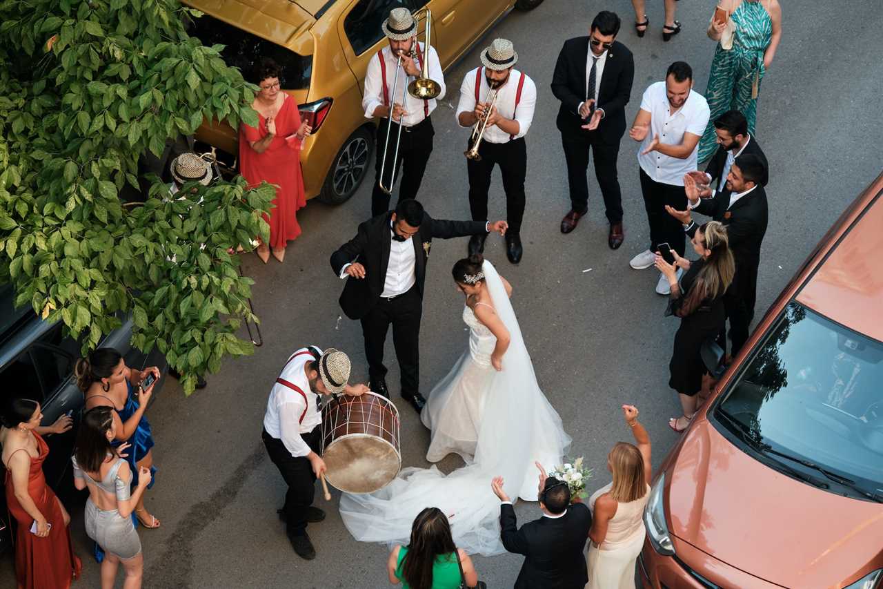 Wedding couple and guests dancing in the street